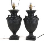 A pair of black painted pottery table lamps in the form of Victorian bronze vases, 30cms (12ins)
