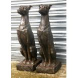 A pair of faux stone (fibreglass) garden figures in the form of seated dogs, 79cms (31ins) high.