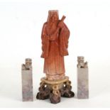 A Chinese carved soapstone figure of a robed scholar, 20cms (8ins) high; together with a pair if