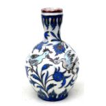 A Persian Qajar pottery vase decorated with birds and foliage in the typical palate, with