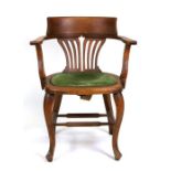 An early 20th century oak desk chair with pierced back splat, upholstered seat and cabriole legs.