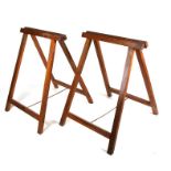 A pair of folding wooden trestles, 58cms (23ins) wide.