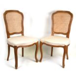 A pair of continental dining chairs with cane backs and upholstered seats (2).