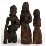 A group of three early carved wooden Asian figures, the largest 20cms (8ins) high (3).