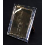 A silver oak backed strut photo frame, London 1917, overall 20 by 26cms (8 by 10.25ins).Condition