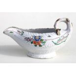 An 18th century English porcelain leaf moulded sauce boat with polychrome painted decoration,