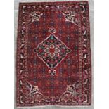 A Persian Kashan woollen hand knotted rug with central medallion within a stylised bird and