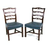 A pair of Georgian style mahogany chairs with blue leather upholstered seats, on square chamfered