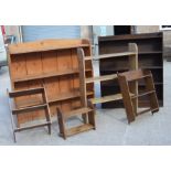 A pine three tier open book shelf, 108cms (42ins) wide; together with another similar, 76cms (30ins)