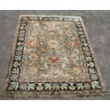 A Persian woollen hand knotted floral design rug on a cream ground, 317 by 239cm (125 by 94 ins)