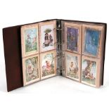 A postcard album containing various cards to include Bonzo and whimsical cards by Mabel Lucie