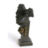 A bronze figural group depicting a maiden kissing the devil, 20cms (8ins) high.