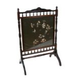 An Edwardian mahogany fire screen with rectangular silk work panel decorated with birds and foliage,