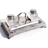 A silver plated desk stand with two cut glass inkwells.