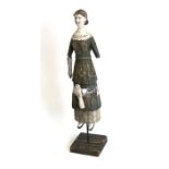 A carved and painted wooden Folk Art style figure of a young woman with articulated arms, 36cms (
