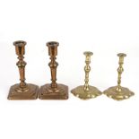 A pair of bronze candlesticks with stepped square bases, one impressed with maker's mark 'HC',