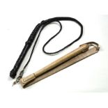 A cream leather strap whip with an overall length of 85cms (33.5ins) together with a black leather