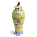 A Chinese baluster vase and cover decorated with scrolling foliage on a yellow ground, the cover
