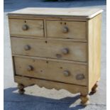 A pine chest of two short and two long drawers, on turned feet, 94cms (37ins) wide.