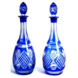 A pair of Bohemian style blue flash glass mallet form decanters, 36cms (14ins) high (2).