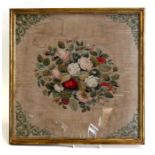 A 19th century needlework panel with central spray of roses, framed & glazed, 37 by 38cms (14.5 by