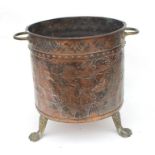 A Dutch two-handled copper log bin decorated with an heraldic crest, on lion paw feet, 36cms (14ins)