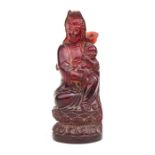 A Chinese moulded amber figure depicting Guanyin, 15cms (6ins) high.