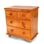 A pine chest of two short and two long drawers, on bun feet, 74cms (29ins) wide.