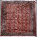 A Persian Turkoman woollen hand knotted rug with six rows of guls within borders, on a beige ground,