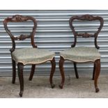 A pair of Victorian mahogany balloon backed dining chairs with over-stuffed seats and cabriole front