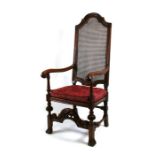 A Victorian 17th century style walnut high-back elbow chair with cane back and seat.