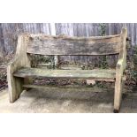 A large rustic well weathered wooden garden bench, 163cms (64ins) wide.