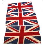 Three early 20th century printed cotton Union Jack flags. Each is marked British Made. 64cms (25.