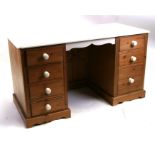 A modern pine twin pedestal desk with an arrangement of seven drawers, 132cms (52ins) wide.