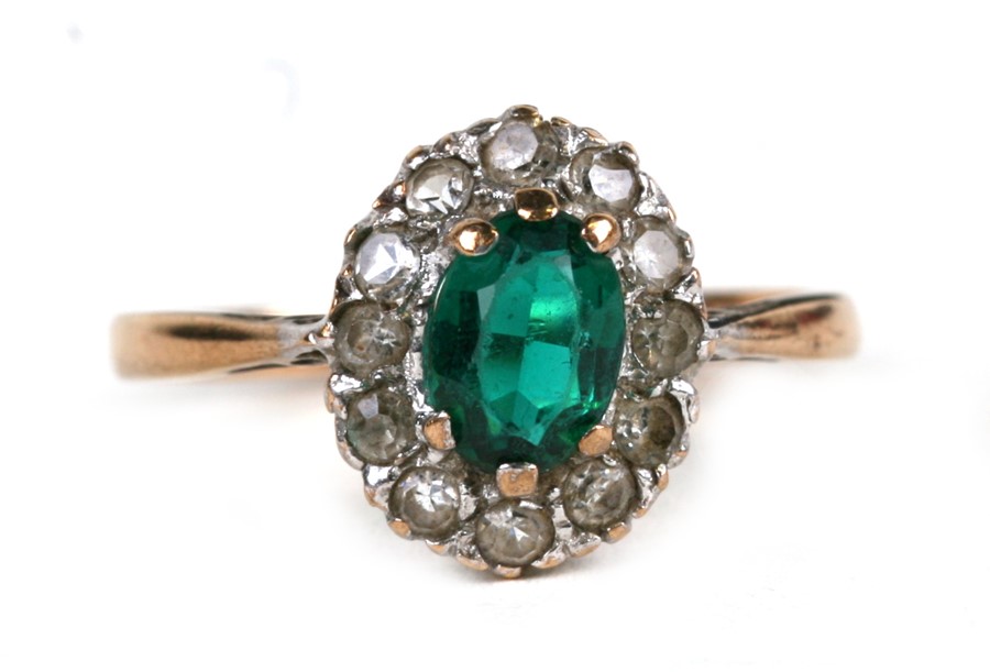 A 9ct gold cluster dress ring set with a central oval green stone, approx UK size 'O'.Condition