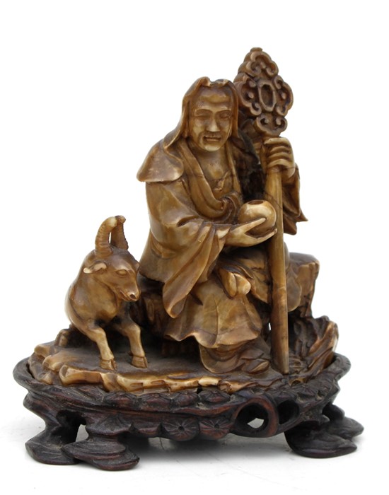 A 19th century Chinese carved soapstone figural group depicting a wise man with a goat, on an