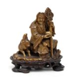 A 19th century Chinese carved soapstone figural group depicting a wise man with a goat, on an