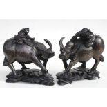 A pair of Chinese hardwood groups depicting children riding water buffalos, profusely inlaid with