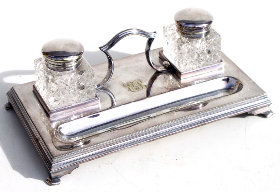 A silver plated desk stand with two cut glass inkwells.