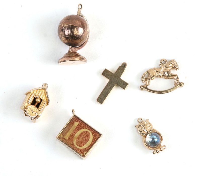 Six 9ct gold charm bracelet charms to include a Cuckoo clock, a rocking horse and a terrestrial