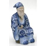 A Japanese pottery figure depicting a scholar holding a scroll, 30cms (12ins) high.