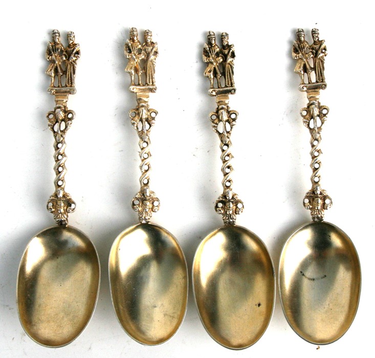 A set of four Dutch style gilt metal marriage spoons with figural finials, 18.5cms (7.25ins) long (