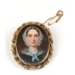 A 19th century hand painted portrait miniature brooch depicting a lady wearing a bonnet, 4..5 by