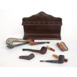 An oak pipe rack; together with a quantity of pipes and cheroot holders.