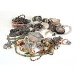 A quantity of costume jewellery to include bangles, bead necklaces & brooches.