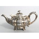 A George III silver teapot of compressed circular form with repousse rose decoration, crested and