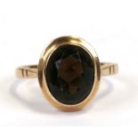 A 9ct gold ring set with an oval smoky quartz, approx UK size 'K'.