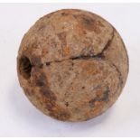 An 18th century excavated exploding cannon ball, approx. 12cms (4.5ins) diameter.