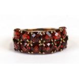 A 9ct gold dress ring set with twelve red stones (possibly garnet), approx UK size 'J'.