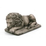 A composite figure of a recumbent lion, 38cms (15ins) long.